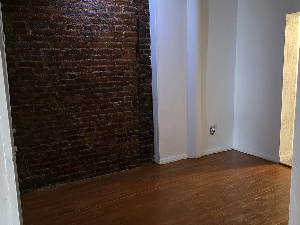 Exposed bricks and hardwood floors, middle room. Dining room.