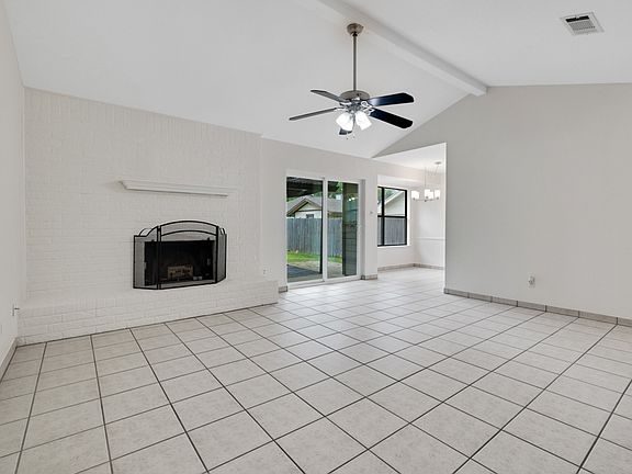 Living area with cathedral ceilings, fireplace and backyard access. Breakfast area in back