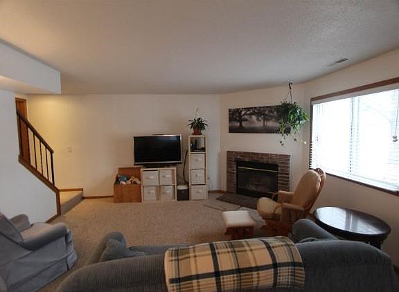 Living room with brick surround gas fireplace and lots of light.