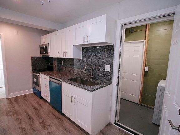 Kitchen with view of full size laundry machines on right