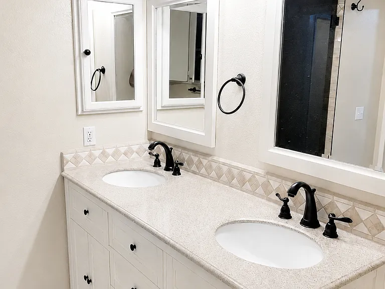 Spacious bathroom vanity area with dual sinks, cabinet storage, and updated fixtures