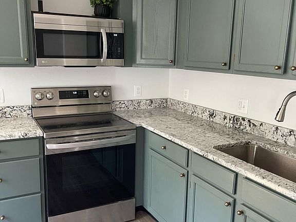 Brand new kitchen with stainless steel appliances and granite countertops