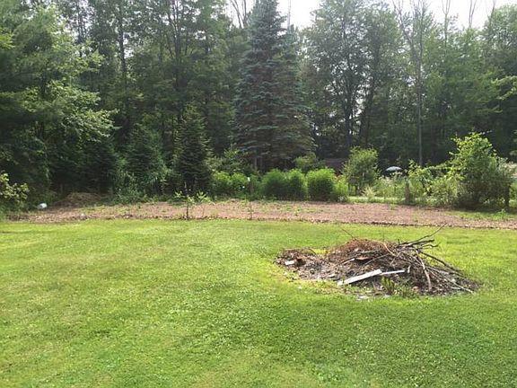The yard has a bonfire pit and large garden area.