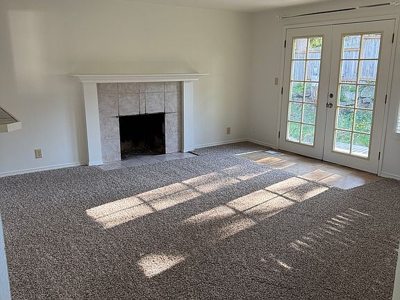 Living room with French doors leading to fenced back yard.