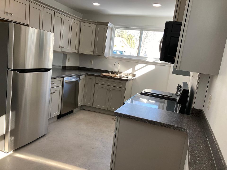 Modern kitchen with all new refrigerator, dishwasher, range and microwave.