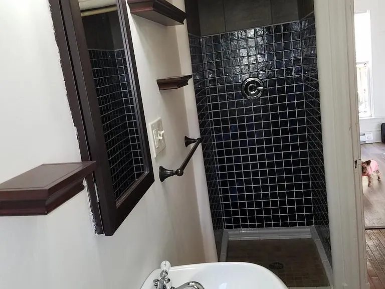 Bathroom shower with original 1940's saved tiles. All new tiles on shower floor and modern flooring.