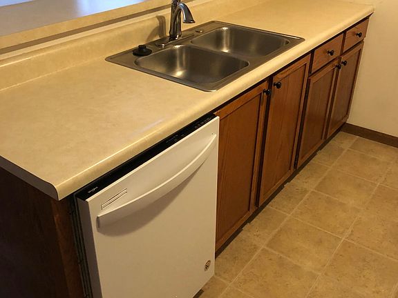 Galley style kitchen with all appliances. Disposal, dishwasher, stove, fridge w/ice maker.