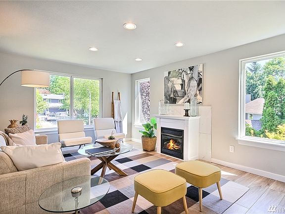 Open floorplan living room with large windows for plenty of natural light and a propane fueled fireplace.