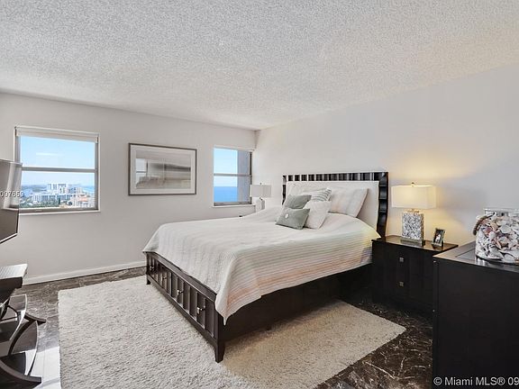 BEDROOM WITH MARBLE FLOORS AND WATER VIEWS