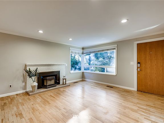 Another view of the open living space shows a fireplace insert for those warm cozy nights and vinyl windows throughout home.