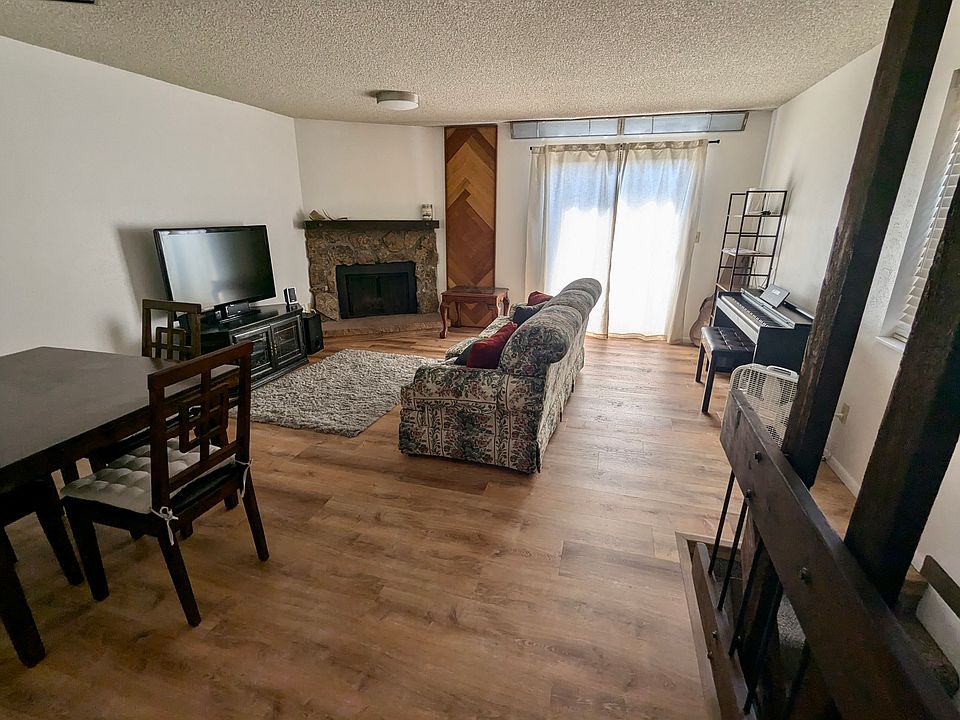 Spacious living room with dining table, TV, couch, and digital piano,