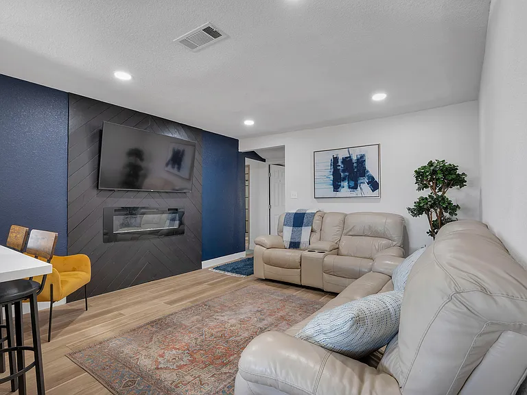 Living room with TV, fireplace, and leather recliners