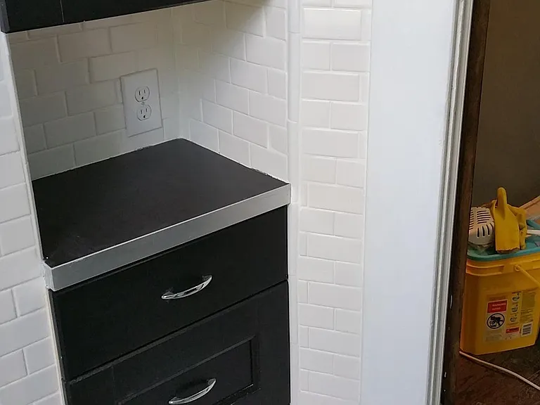 Fresh tile floor, counter, drawer and cupboard space make for an inviting, bright bathroom!