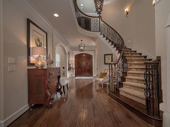 Entry way features wood flooring and views of the sweeping stairway!