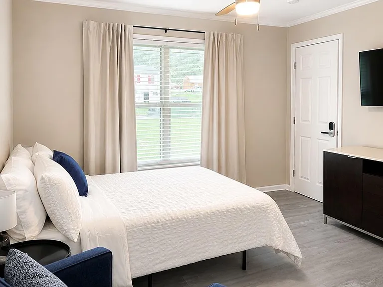 A ceiling fan, blackout curtains and blinds for temperature and light regulation.