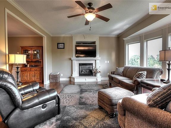 Living room with fireplace and beautiful large windows to wooded area.