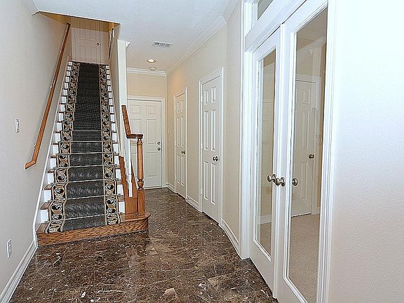 Stairway to the second floor living and dining. The first floor features a guest bedroom, full bath 