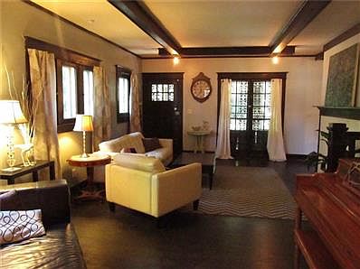 Formal living room has hardwood floors, rewired ceiling fixtures and one of the fireplaces which was custom built with solid oak Craftsman style mantels and surround reclaimed large white marble tiles.  (Original gas supplies for future inserts.)