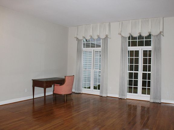 Living room off entry with hard wood floors and custom curta