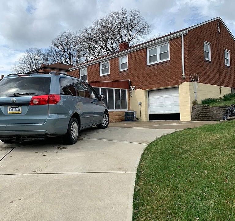 Driveway and one car garage, second outdoor parking area beside Van.