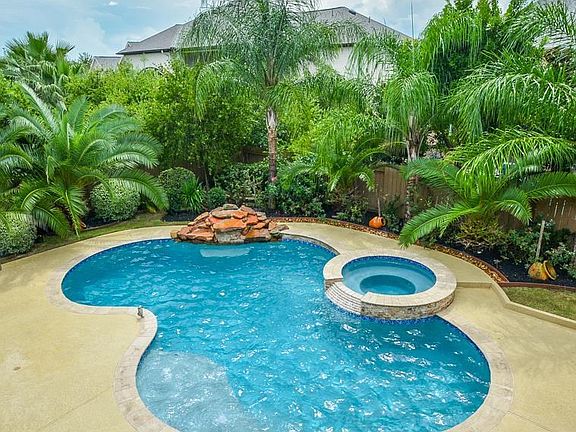 Take a dip in this sparkling pool and hot tub with a waterfall feature.