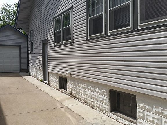 Driveway, detached 1 car garage, and side entrance
