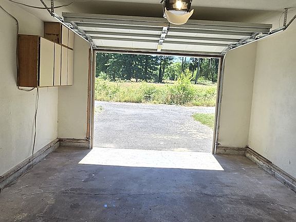 Single car garage with door opener and cabinets for storage