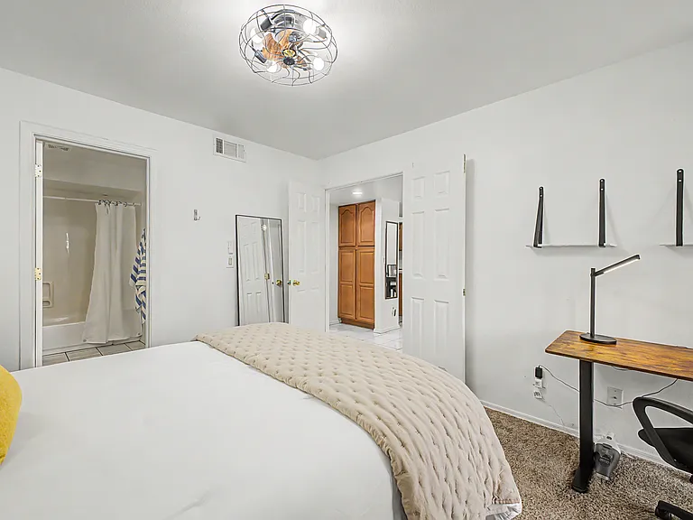 1st floor primary suite includes bathroom, patio access, sit/stand desk, & comfortable queen bed sleeps 2