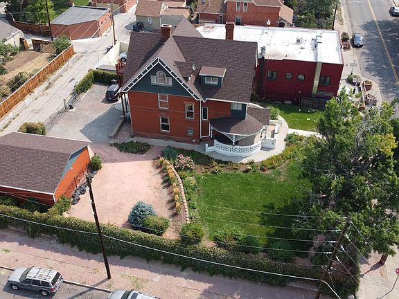 Aerial view of property including gated parking at back of property.
