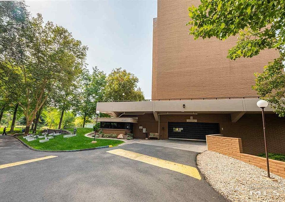 Building entrance with security office on left and garage gate in center.