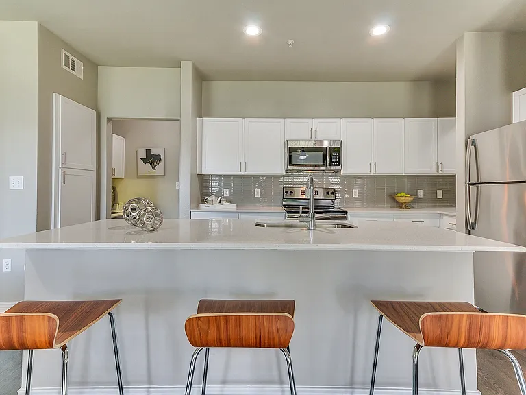 Stunning kitchens include quartz countertops and custom-patterned tile backsplash.