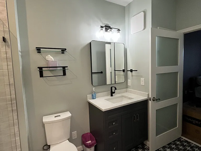 Modern bathroom showing door to bedroom