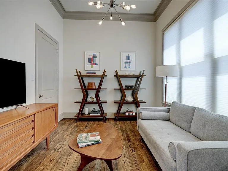 The dining area, currently setup as another living space, large storage closet, and oversized windows with cellular shades.