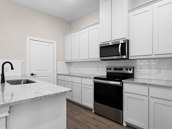 The kitchen has a beautiful tile backsplash.