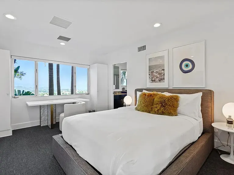 Modern bedroom with desk space and a window showcasing breathtaking views, offering a serene and inspiring environment.