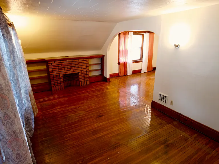 Living room looking into the dining room area. Original hardwood floor.