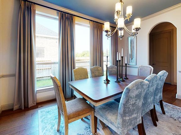 Expansive windows bathe this dining room with natural light, creating a lovely statement space to ho