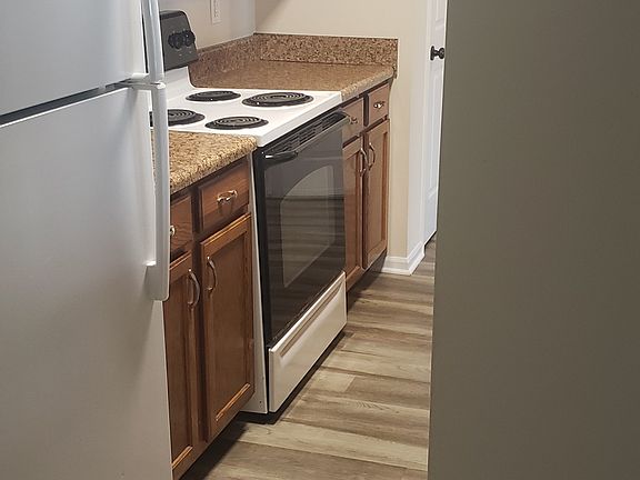 Galley kitchen, with refrigerator, range, microwave & dishwasher.