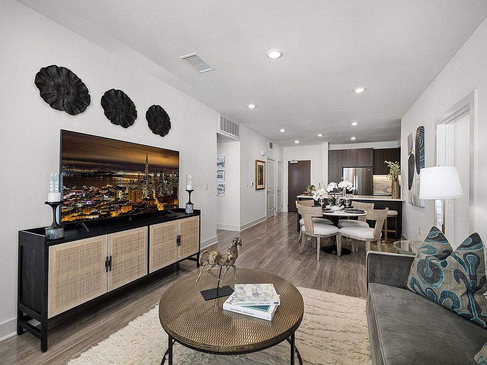 Living space with media console, wide windows, and soft textures