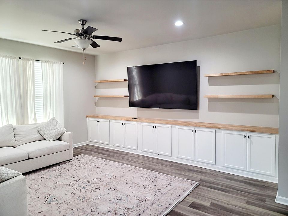 Living Room w/ built in and floating shelves. HDMI wires/electric plugs located in cabinets.