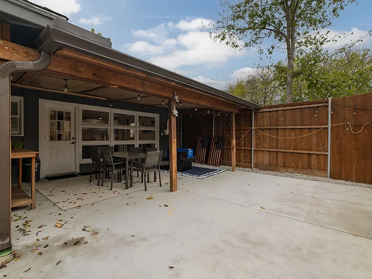 Covered patio with a dining table for six, plus fun outdoor games including bocce ball, life-size Jenga, and cornhole. A great spot for meals, gatherings, and laid-back backyard entertainment.