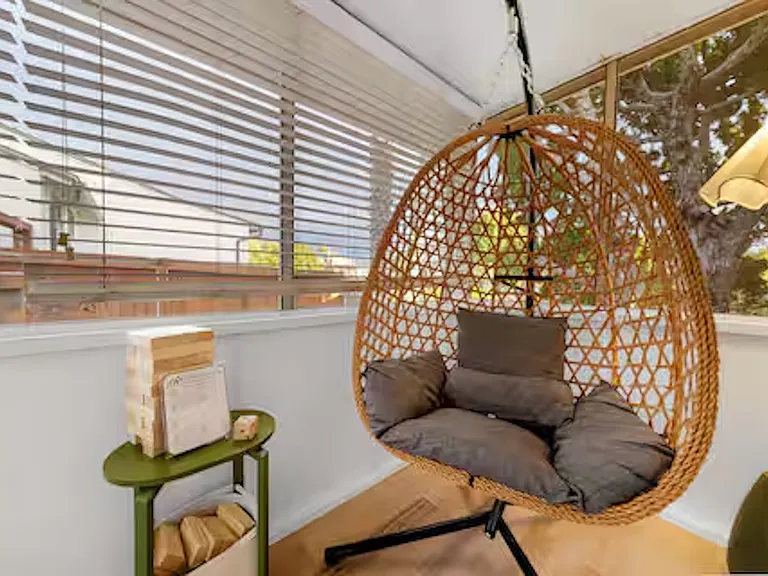 Sunroom accessible directly from bedroom with bunk beds, providing a bright, relaxing space to unwind and step out to the outdoor area.