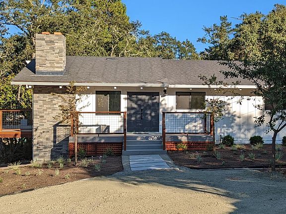Front of home from main parking area. Showing back (main) deck, front door deck, and master bedroom deck.