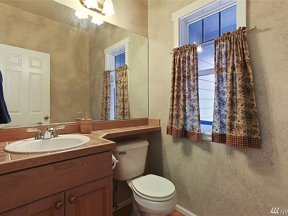 Main floor powder room features tall ceilings, tiled vanity and hardwood floors. 