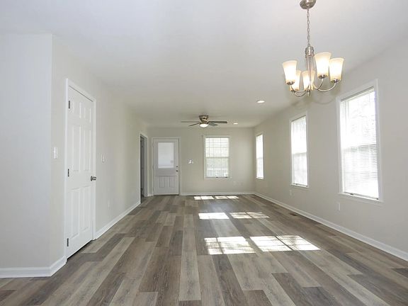 non furnished living room dining room combination looking from kitchen to front door. Coat closet on the left. Alot of natural light from windows.