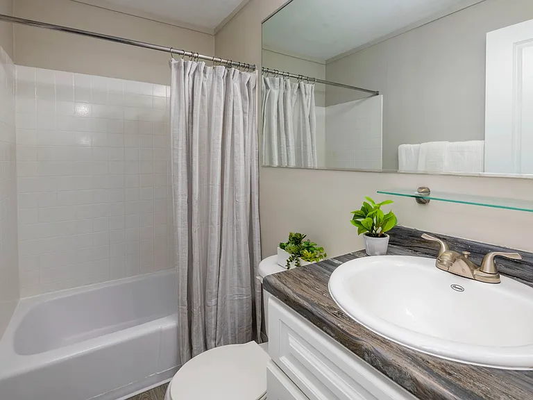Discover the allure of our thoughtfully designed bathroom space elevated by a generous mirror at Aspen Chase.