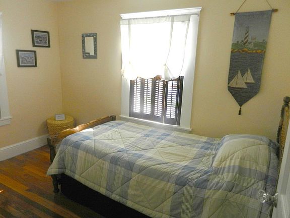 Southeast bedroom with twin bed and folk art decorations.