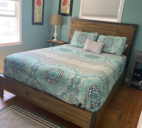 The bedroom has a queen bed, closet and dresser