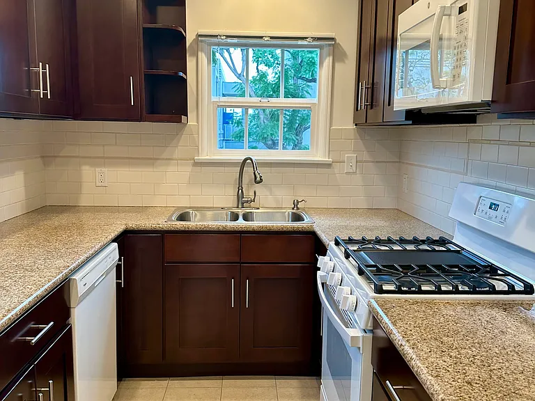 Window above kitchen sink, great shelving, and modern tiled flooring