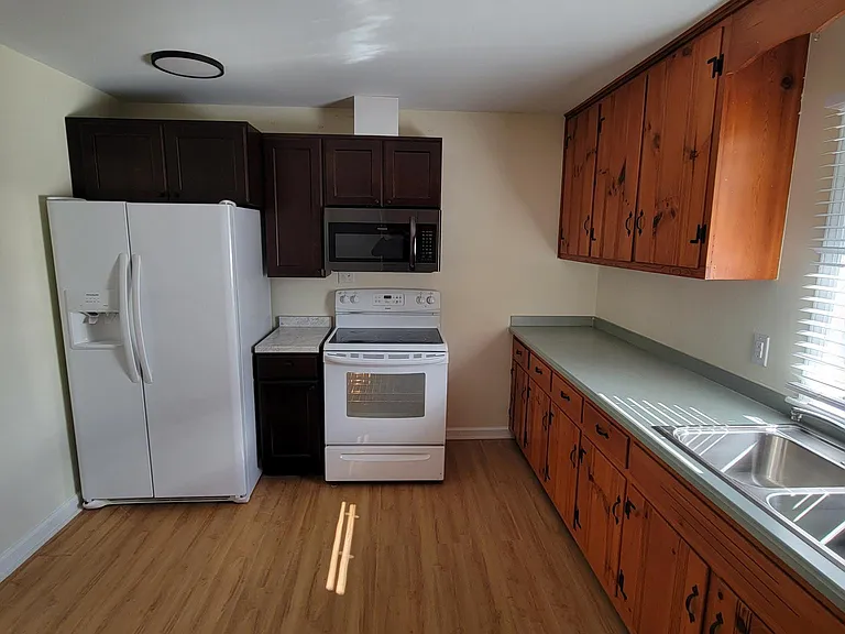 New cabinets in corner. New lights, microwave, newer fridge, clean range, new disposal.